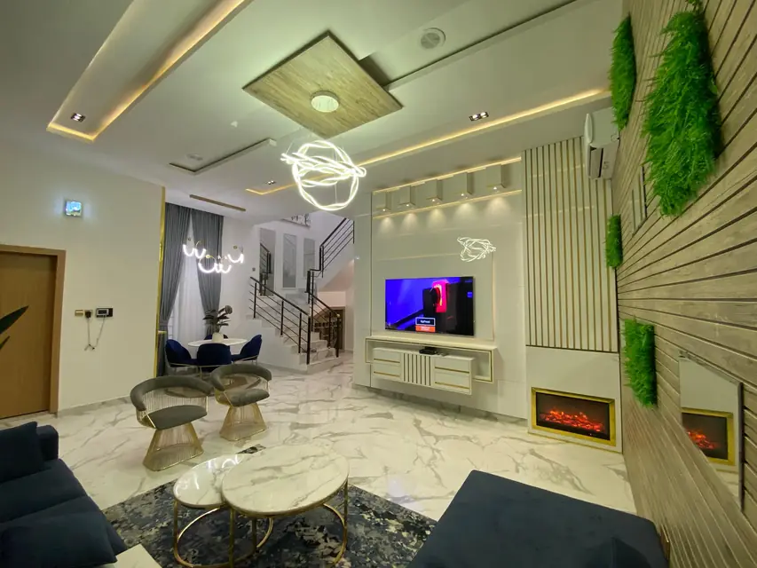 Living room with a green plant wall, fireplace and marble flooring