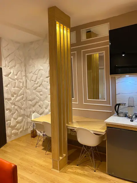 Dining nook with a timber slat divider and textured white wall panels