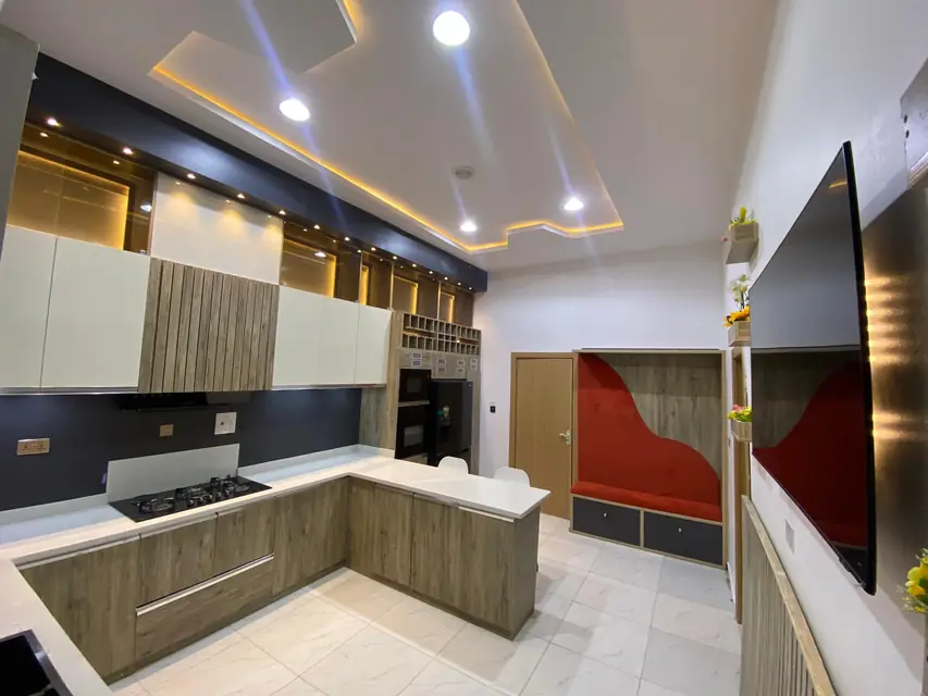 L shaped kitchen with wood finish cabinets and a built in hob