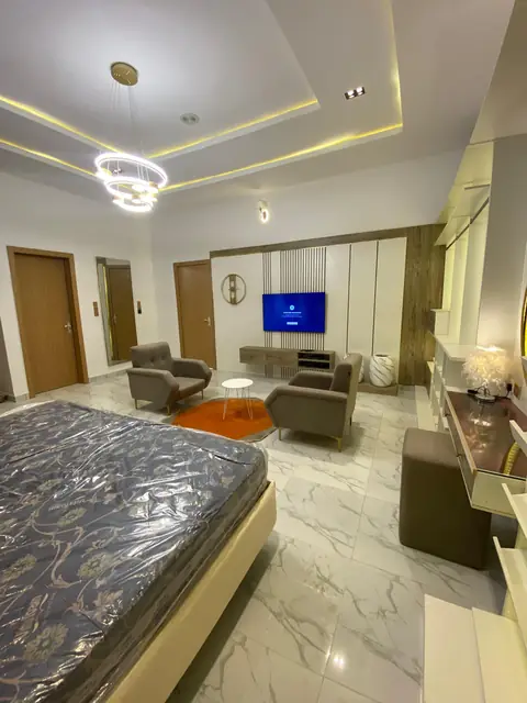Bedroom with a sitting area and a ring chandelier