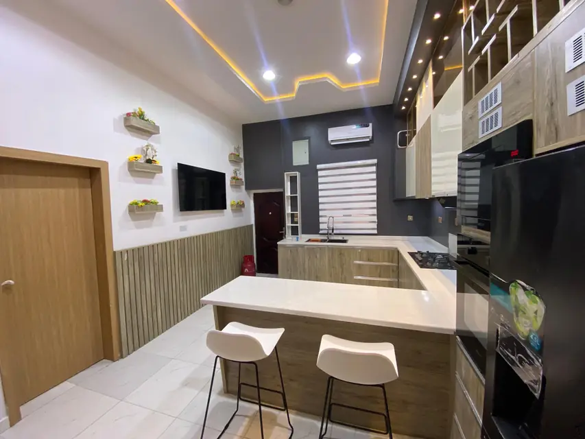 Kitchen with white bar stools and wood panelled walls